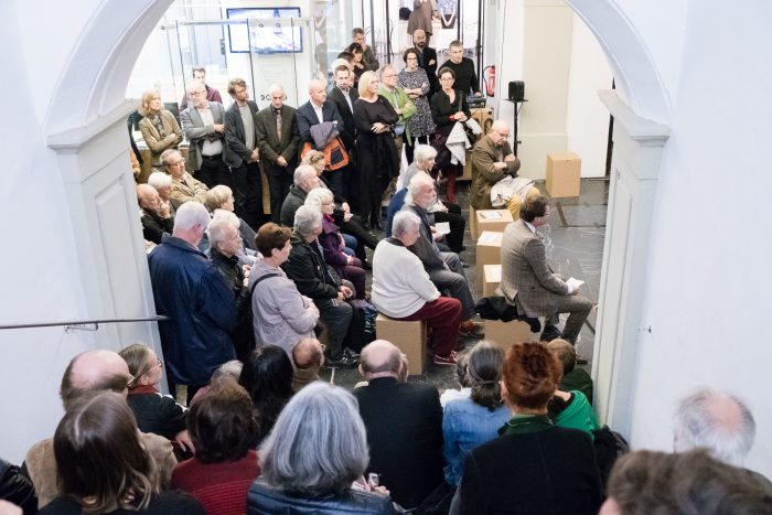 Eine Gruppe von Personen bei einer Veranstaltung der Republik 1918-1938, sitzend und stehend, in einem Innenraum in Graz.
