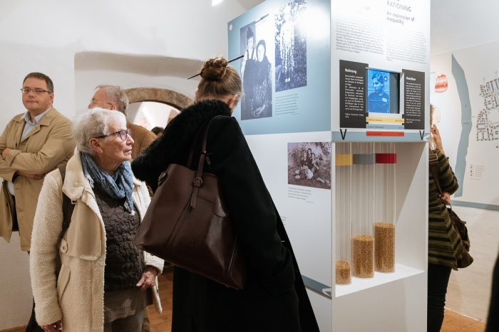 Besucher erkunden die Informationstafeln in einer Innenausstellung des Museums Lager Liebenau.
