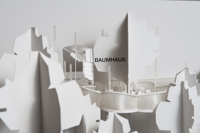 Weißes Architekturmodell mit der Aufschrift BAUMHAUS, das ein urbanes Design mit abstrakten Bäumen und modernen Formen zeigt.