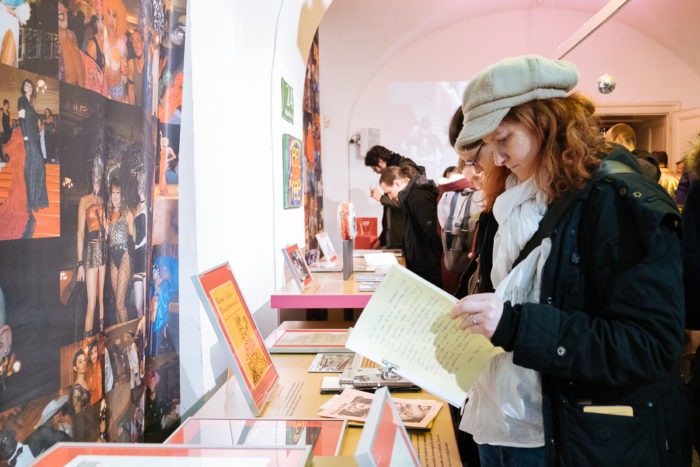 Frau beim Lesen eines Dokuments in einer ganz normal anderen Museumsausstellung mit Fotos und Displays.
