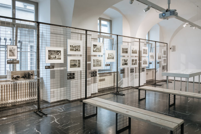 Kunstgalerie mit gerahmten Fotografien auf Drahtplatten, Bänken und Herz von Sturm im Blick.