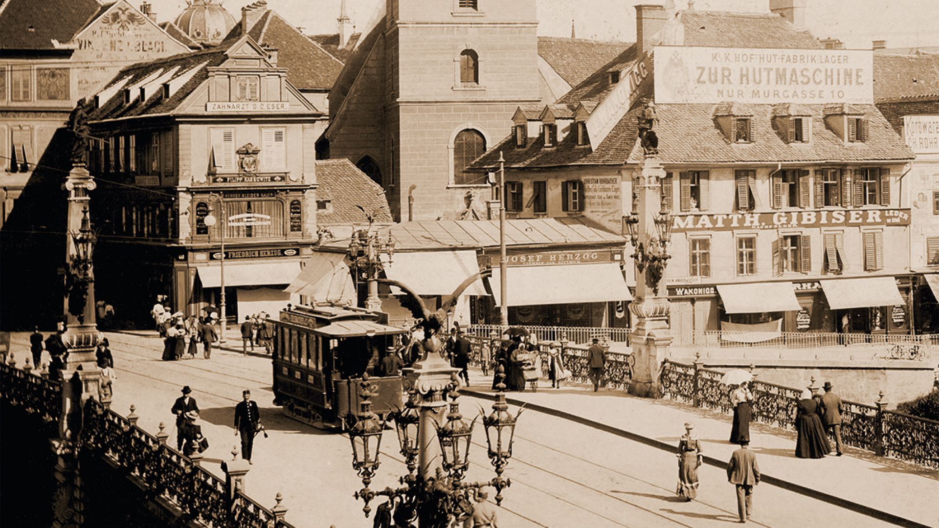 Historische Straßenszene mit einer Straßenbahn, Fußgängern und Boulevards in einer europäischen Stadt.