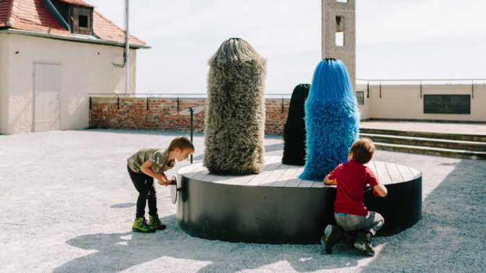 Zwei Buben spielen mit einer Aktivstation im Wundergarten des Graz Museums Schlossberg.