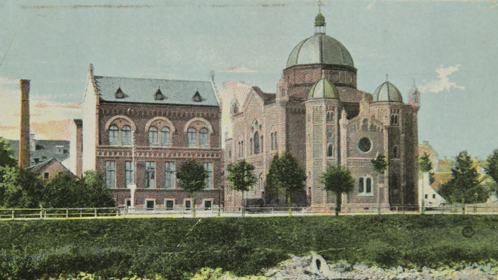 Historisches Backsteingebäude mit großer Kuppel in der Nähe einer Grünfläche, die die reiche Geschichte von Graz widerspiegelt.