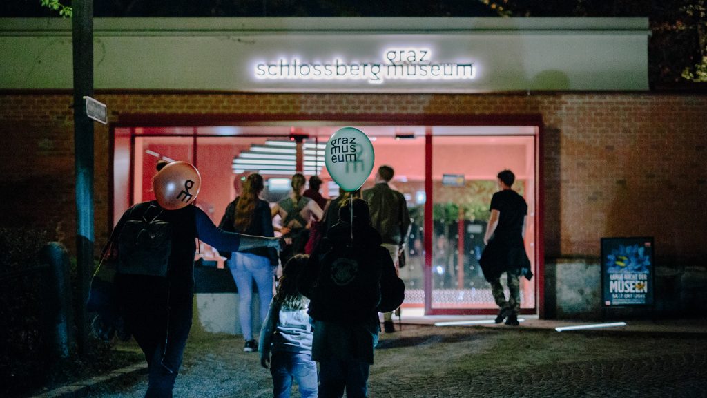 Besucher betreten das Grazer Schlossbergmuseum bei der Langen Nacht der Museen mit Luftballons.