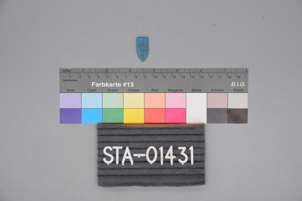 Farbkalibrierungsdiagramm, graues Pad mit der Aufschrift STA-01431 und kleines blaues Schild-Emblem.