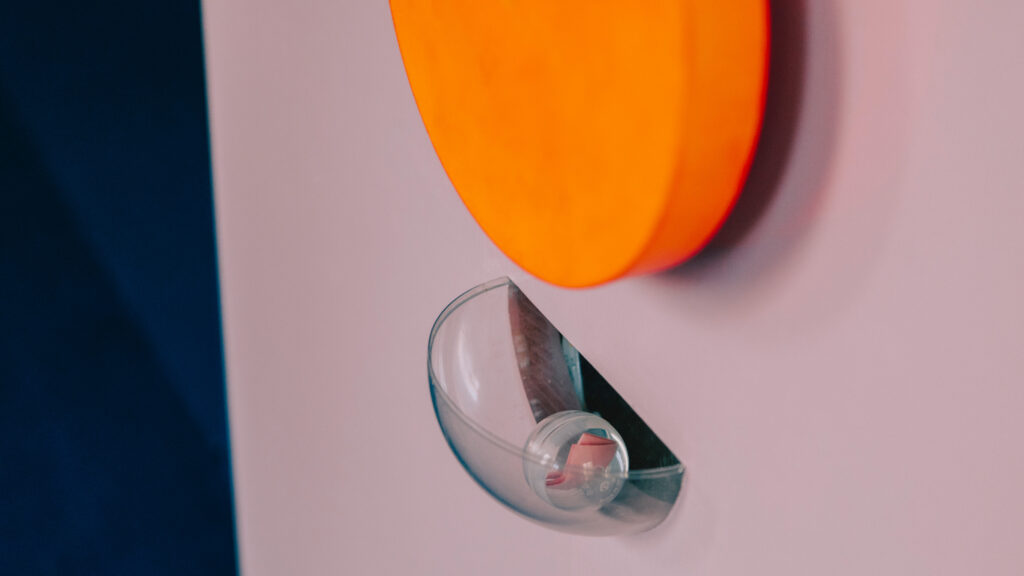 Ein Klebebandspender auf weißem Hintergrund, über dem ein orangefarbener Kreis für einen Hauch von Optimismus sorgt.