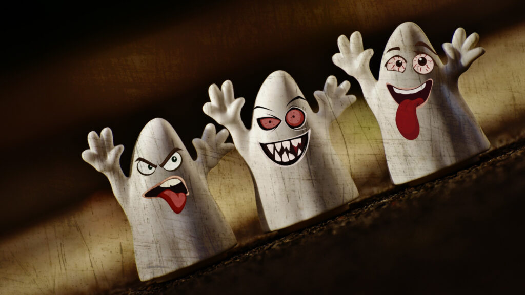 Drei Geisterfiguren aus einem Halloween-Workshop mit lustigen, ausdrucksstarken Gesichtern und erhobenen Armen.