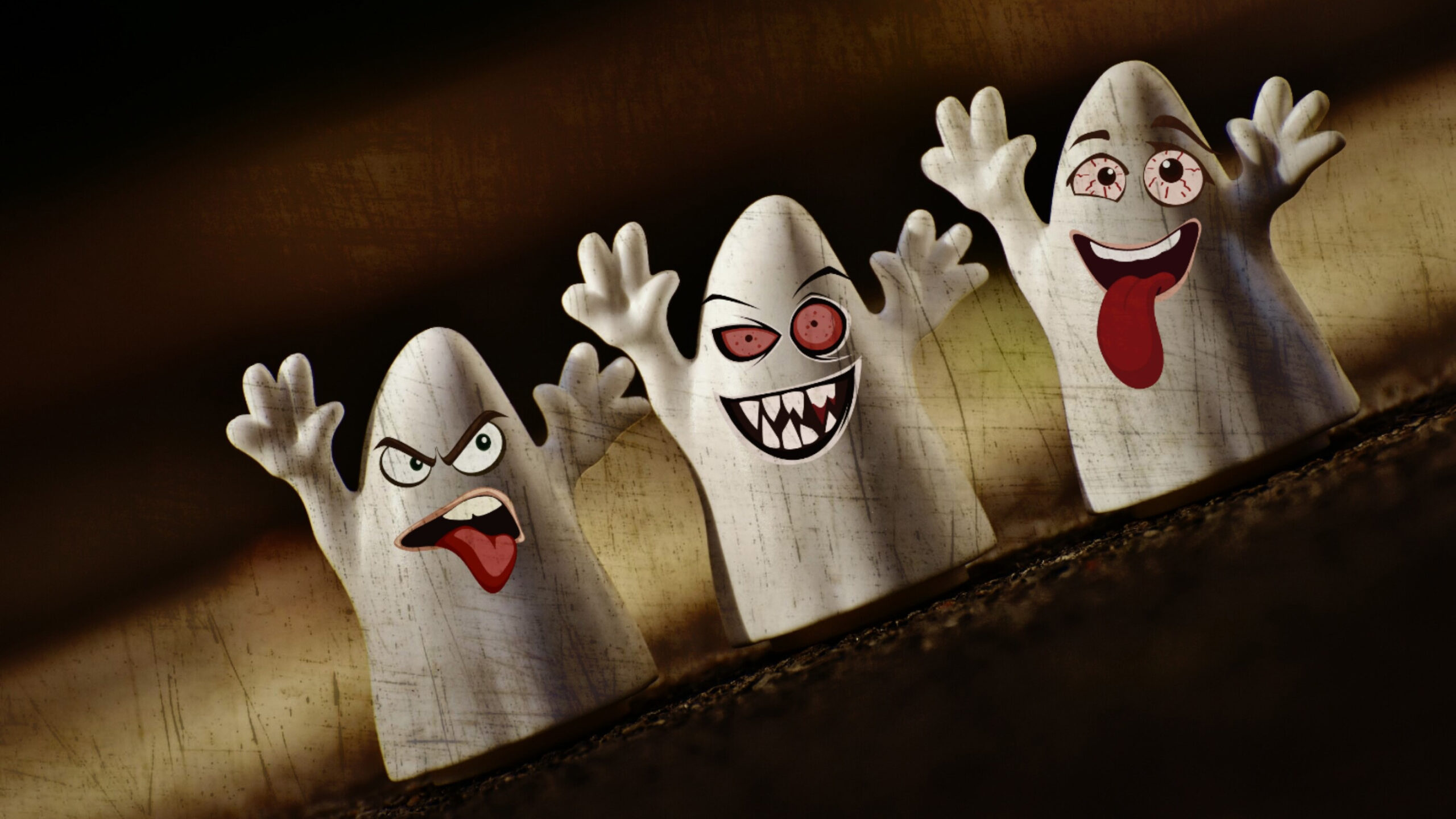 Drei Geisterfiguren aus einem Halloween-Workshop mit lustigen, ausdrucksstarken Gesichtern und erhobenen Armen.